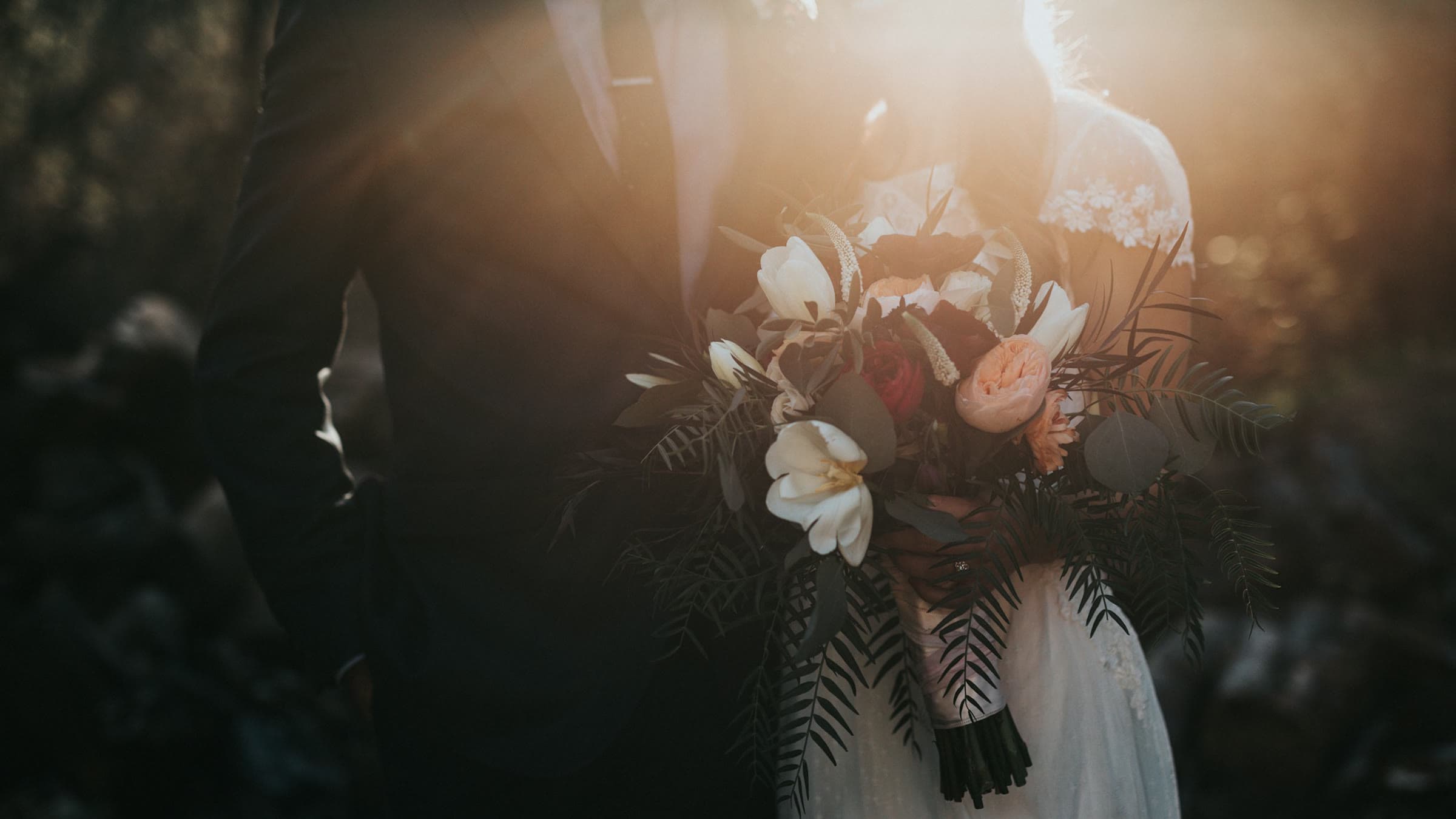 Jeunes mariés marchant main dans la main dans un jardin, image extraite d'un film de mariage
